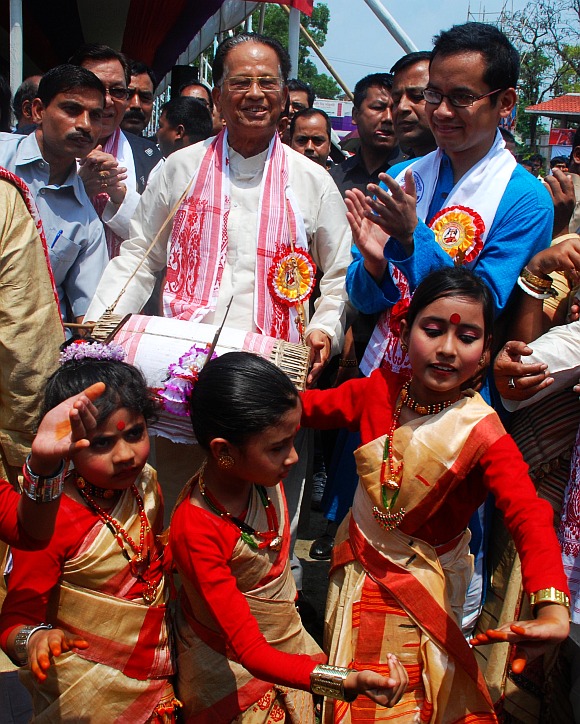 Assam Chief Minsiter Tarun Kumar Gogoi beats a dhol while children perform Bihu