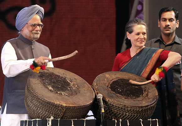 Prime Minister Manmohan Singh and Congress chief Sonia Gandhi play a folk drum